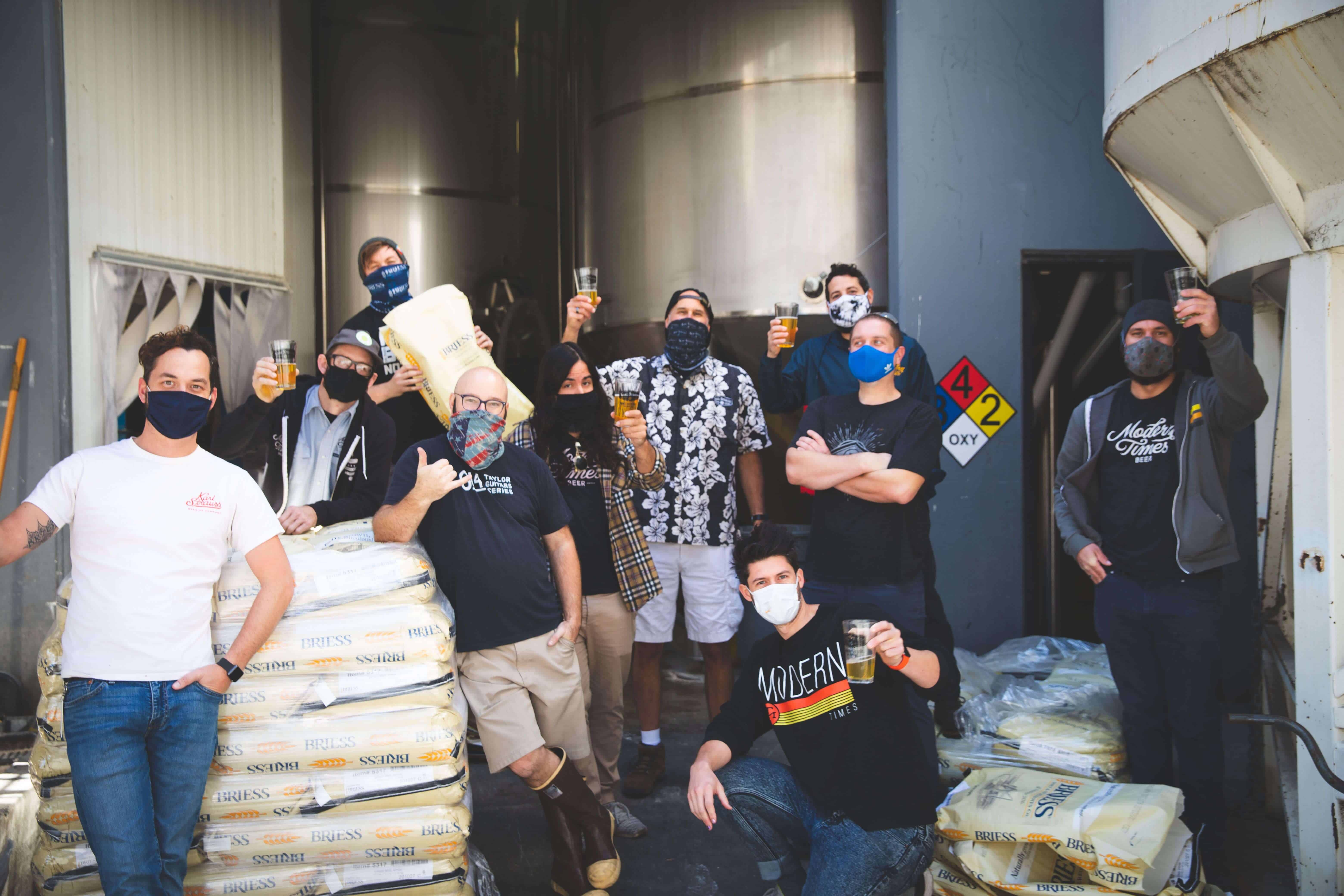 Group of People posing with beers in the brewery