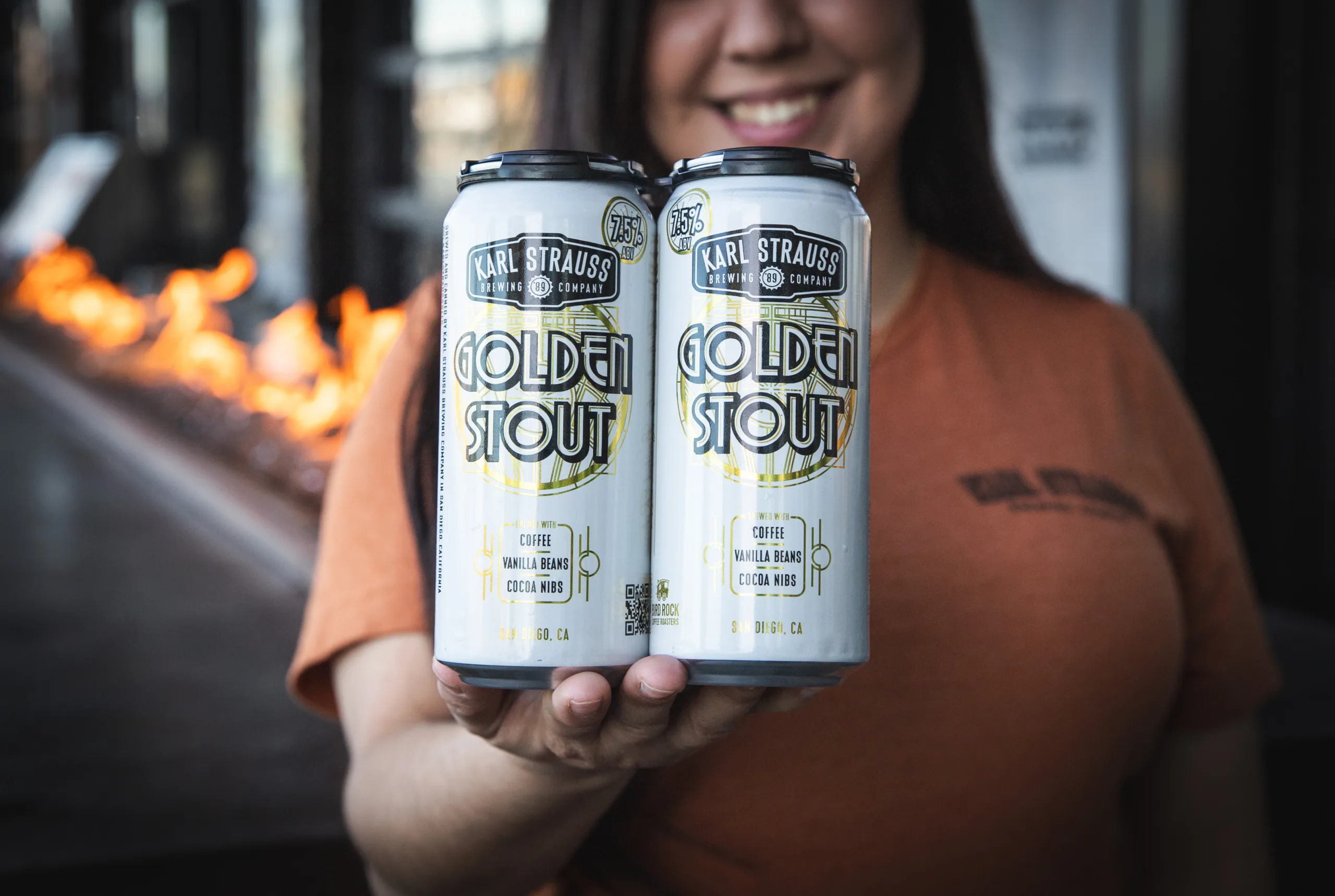a woman holding two cans of beer