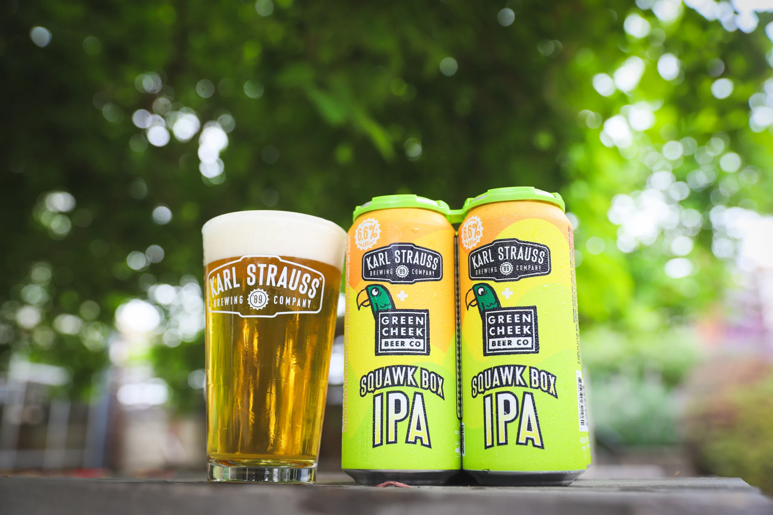 two cans of beer next to a glass of beer